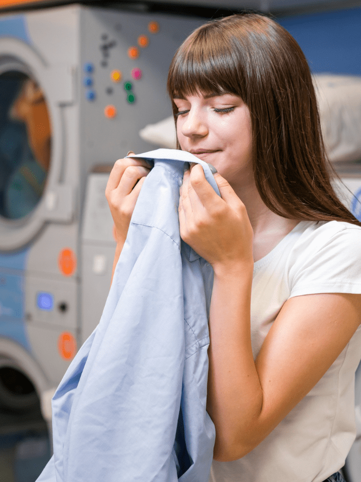 Mujer en una lavandería con camisa en mano 